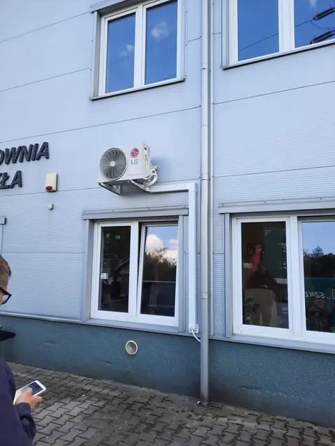 Jednostka klimatyzacji na ścianie budynku biurowego nad oknem
